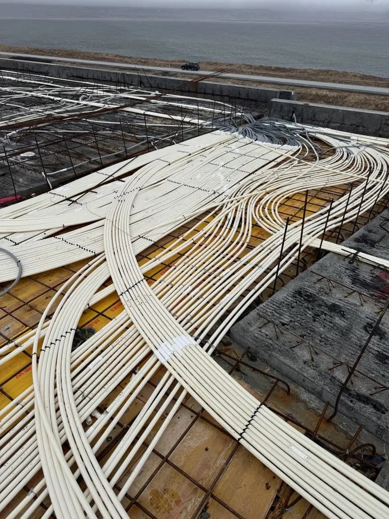 Conduits laid across a floor slab before the concrete pour