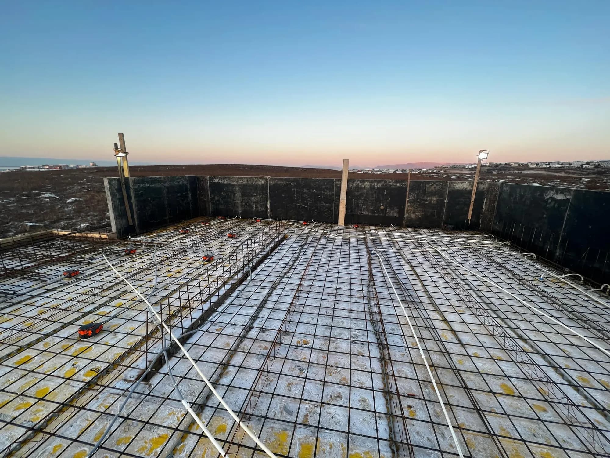 Floor slab with conduits before the pour, at sunset