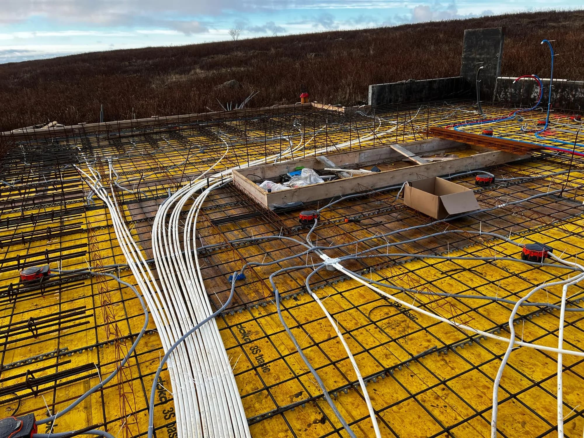 Conduits and boxes across a floor slab before the pour