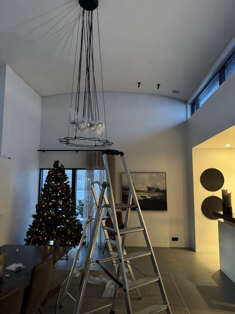 Chandelier being installed in a living room