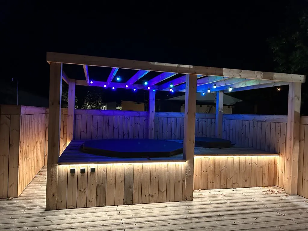 Deck with a hot tub and lighting